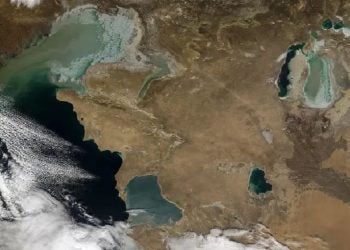 Imagem espacial mostra o Cáspio parcialmente coberto por nuvens. À direita, o que resta do Aral, fragmentado em duas partes.NASA