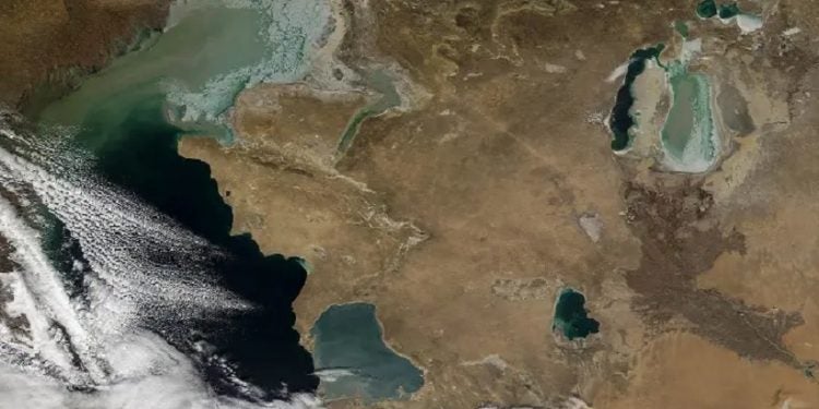 Imagem espacial mostra o Cáspio parcialmente coberto por nuvens. À direita, o que resta do Aral, fragmentado em duas partes.NASA
