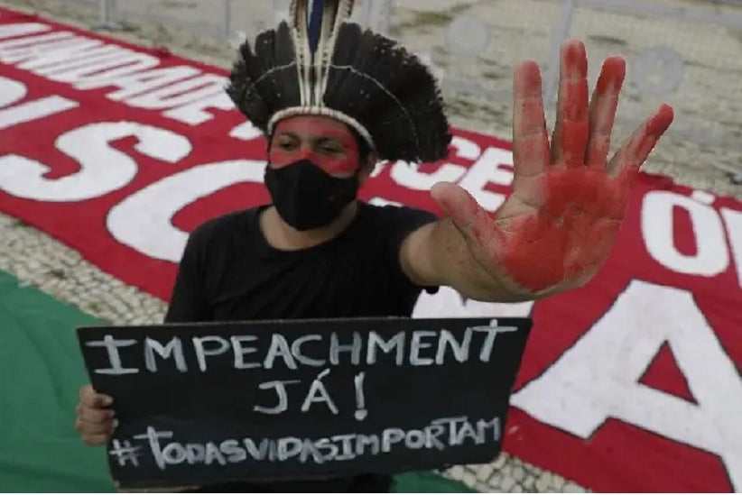 Manifestante protesta contra o presidente Jair Bolsonaro na frente do Planalto, no último sábado. ERALDO PERES (AP)