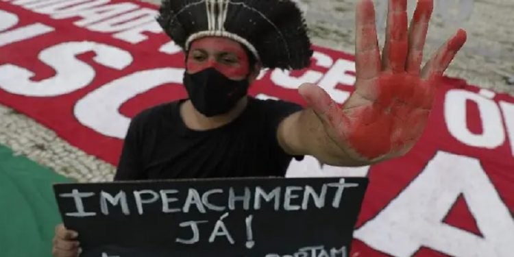 Manifestante protesta contra o presidente Jair Bolsonaro na frente do Planalto, no último sábado. ERALDO PERES (AP)