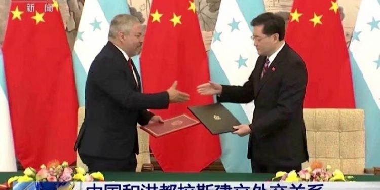 Los cancilleres de Honduras, Eduardo Enrique Reina García, a la izquierda, y el de China, Qin Gang, intercambian acuerdos durante una ceremonia de firma en Beijing, el 26 de marzo de 2023. (CCTV a través de AP)