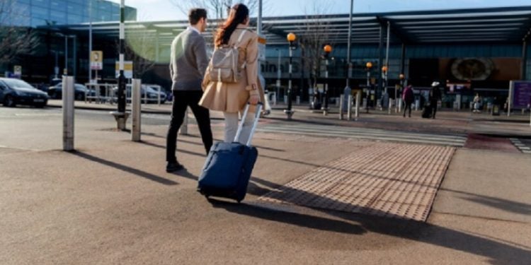 Descrição da Imagem (ALT) - Um casal caminhando em direção ao aeroporto Fonte: freepik