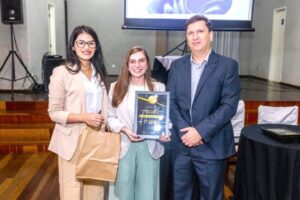 Amabily Fruttos e Rafaela Buono, técnicas do Observatório Social em Foz do Iguaçu, recebem o prêmio do presidente da Rede OSB, Jean Pedroso – foto: Divulgação/OSB