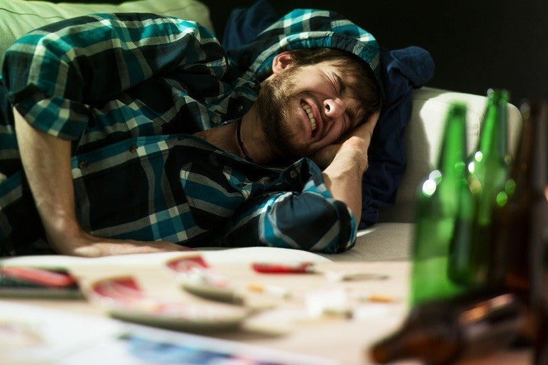 Young student having terrible headache after party