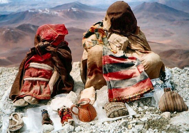 Duas das crianças encontradas no cume do Llullaillaco, a donzela e o menino, junto com seus artefatos.