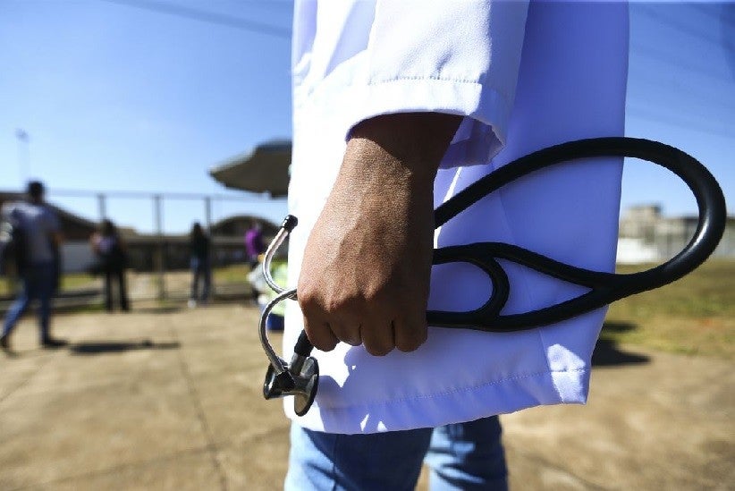 Profissional de saúde com estetoscópio na mão