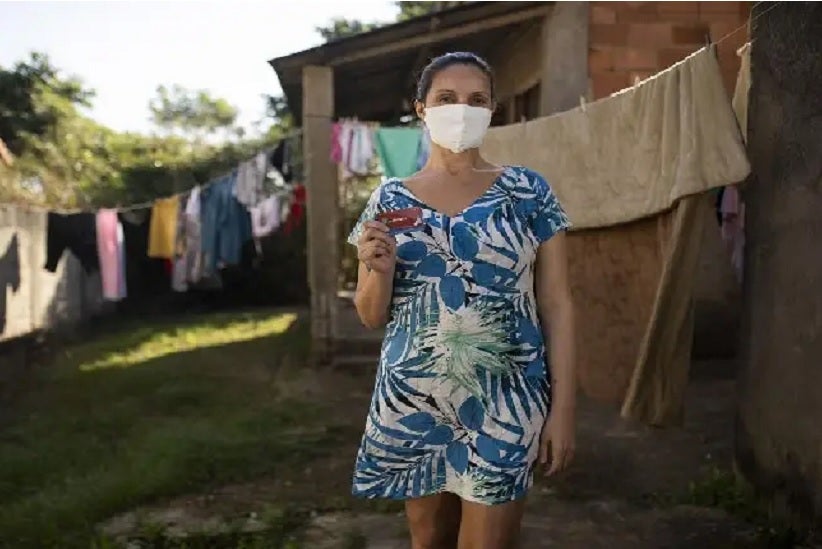 Luciana de Souza Nunes mostra o cartão com o auxílio da prefeitura em sua casa, em Maricá. Fernando Souza