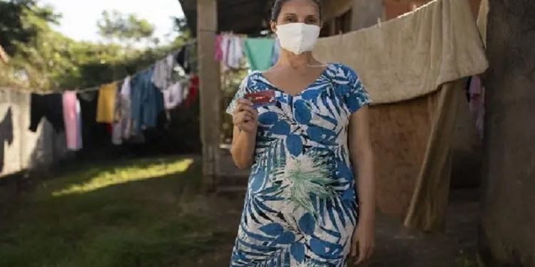 Luciana de Souza Nunes mostra o cartão com o auxílio da prefeitura em sua casa, em Maricá. Fernando Souza