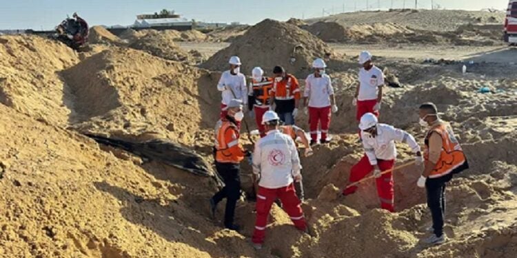 Equipes do Crescente Vermelho e da Defesa Civil palestina escavam em vala comum em busca de corpos dos socorristas (Jonatthan Whittall/X)