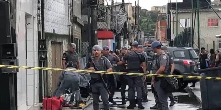 Corpo do adolescente à esquerda do cordão policial. Mais uma vítima da Operação Escudo - Foto: Divulgação