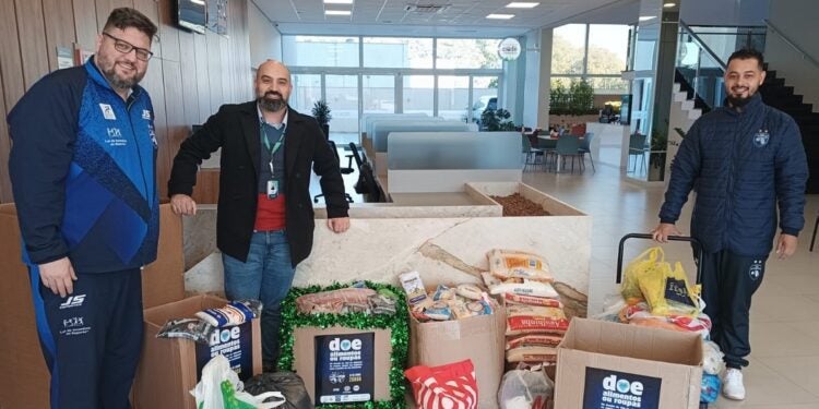Reunindo os donativos, Marlus Sokolowski, treinador do Foz, Wilson Serrano, do Sicoob, e Jeferson Biron, da diretoria do time – foto divulgação
