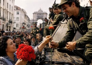 Cravos nos fuzis simbolizaram a união entre povo e militares na queda da ditadura. Foto: Reprodução/Internet.